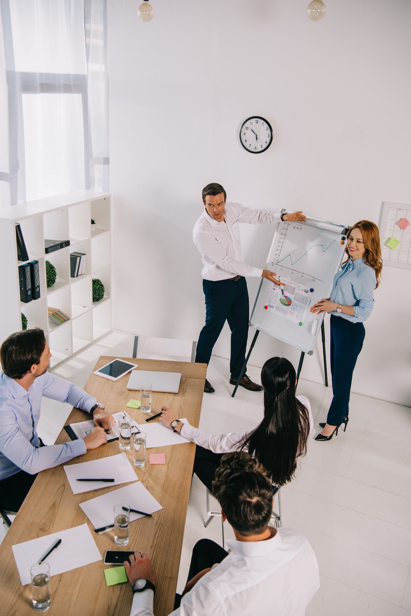 high angle view of business coworkers at white board having business training in office
